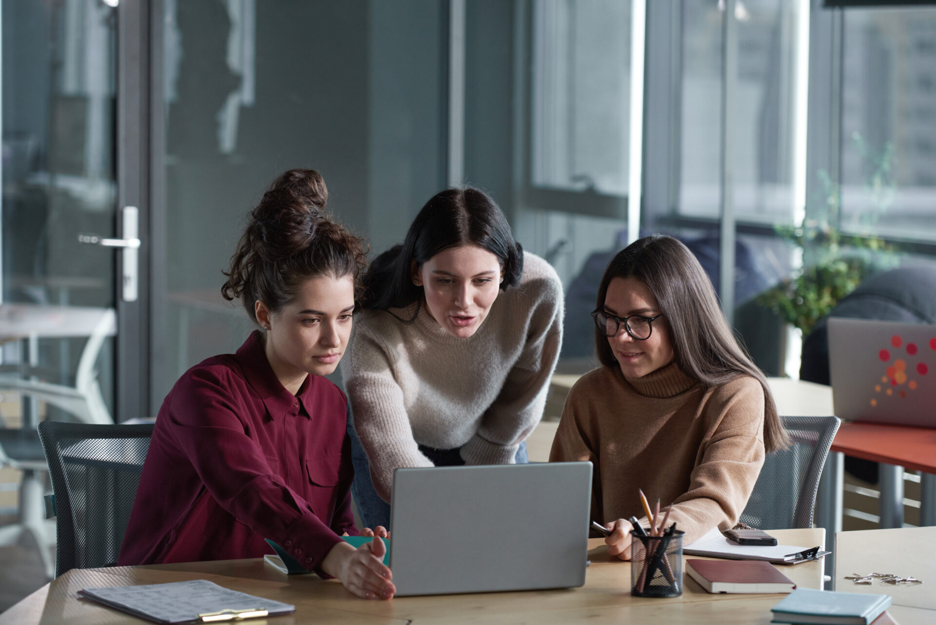 Finance team collaborating on a laptop in a modern office, evaluating automation solutions to streamline processes and enhance operational efficiency in the Office of Finance.