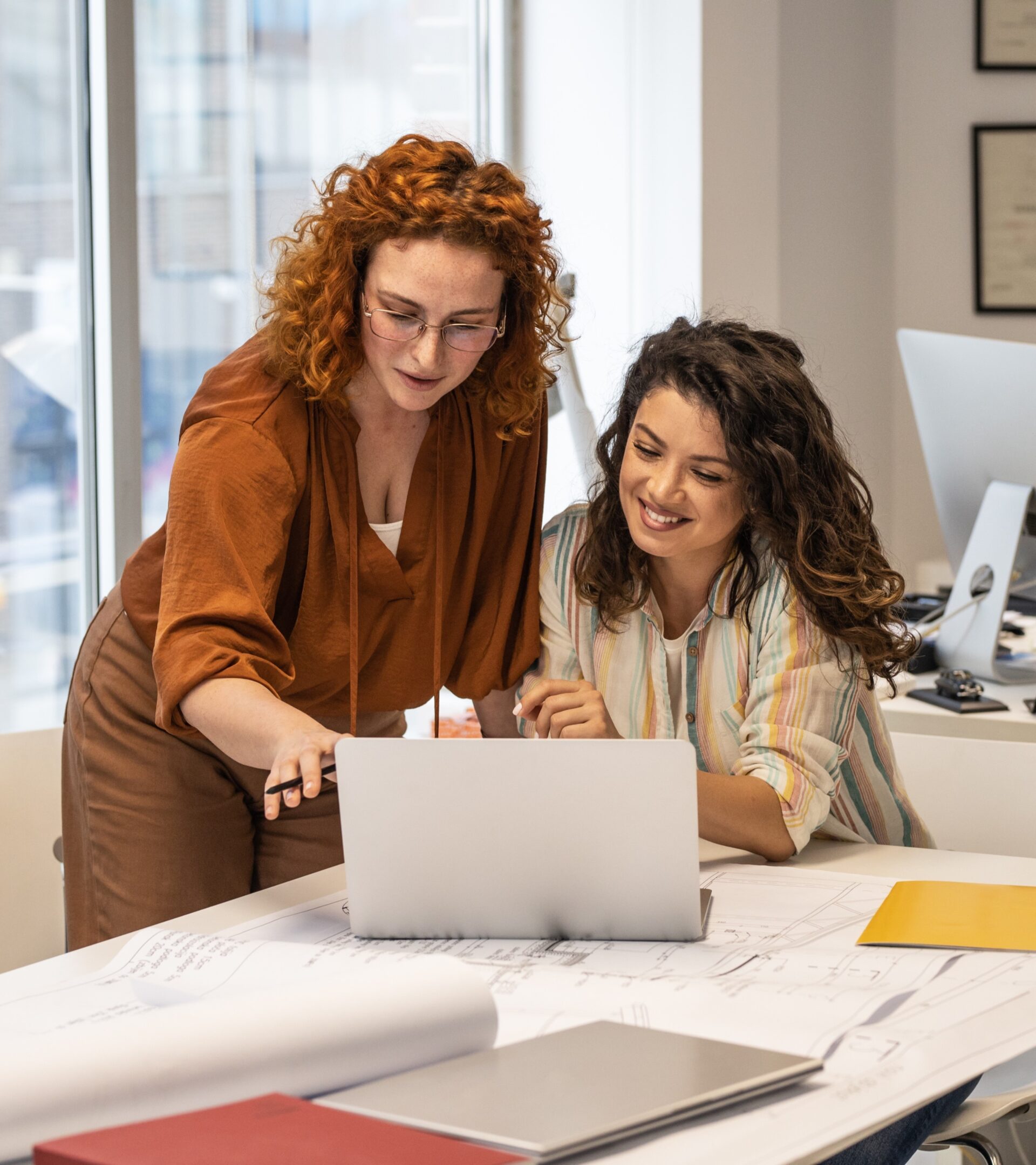 Two women working going over the transaction matching reports,