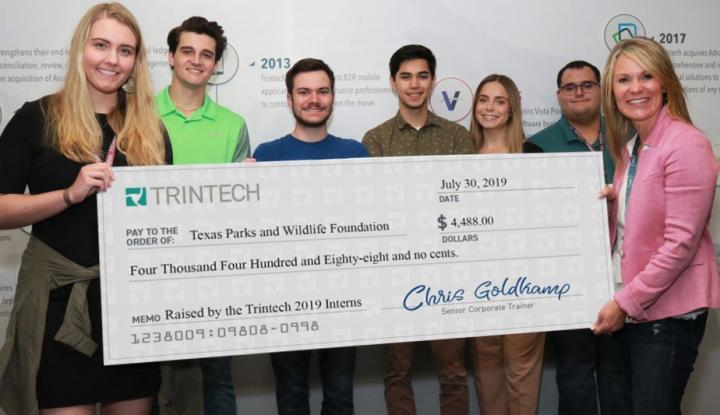 Trintech team holding check