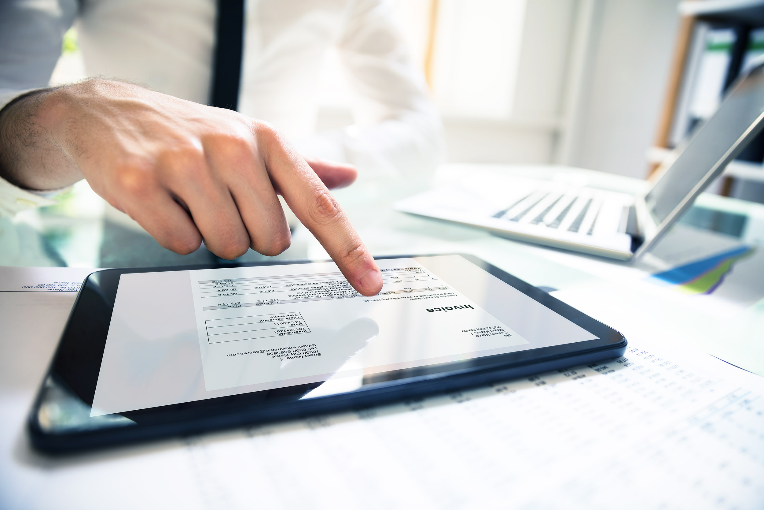 Persons hand touching an ipad with a reconciliation on the screen