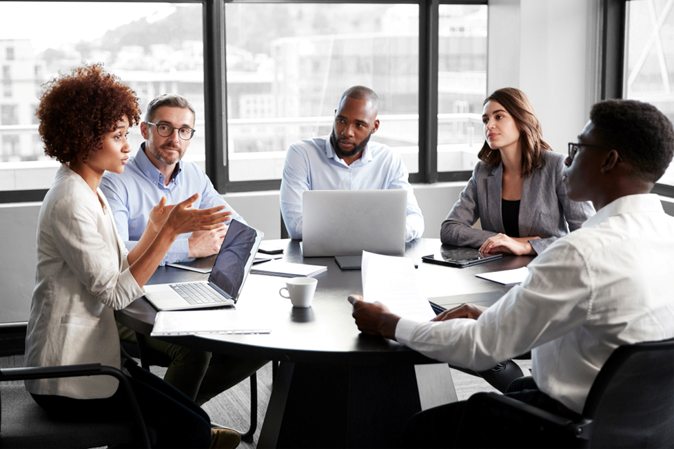 Finance team sitting around a desk discussing Cadency Certification