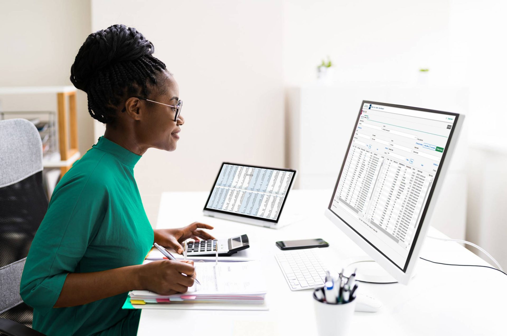 Lady sitting at desk working on computer with a screenshot of Trintech's software