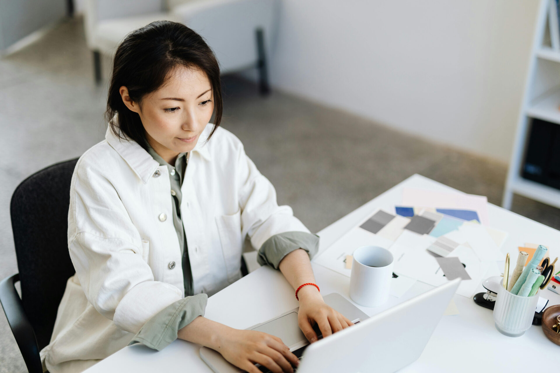 Woman sitting at a table while working on her laptop.