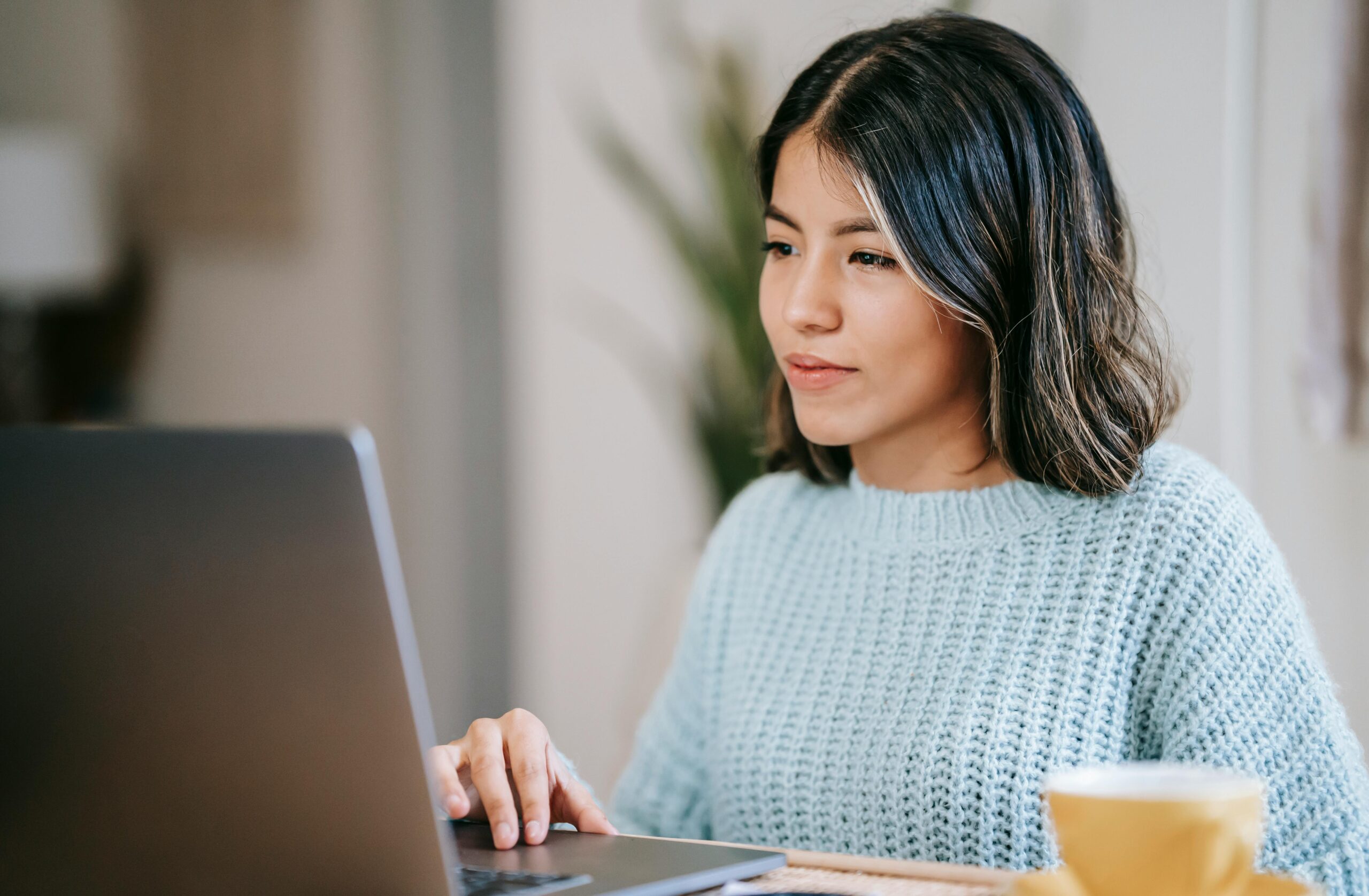 Young woman smiling at her laptop while working