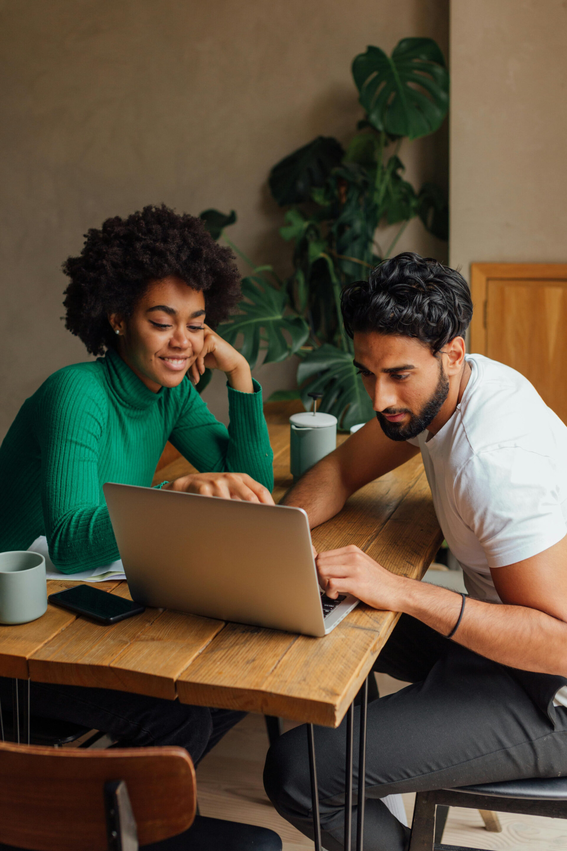 Young coworkers going over reports together on a laptop