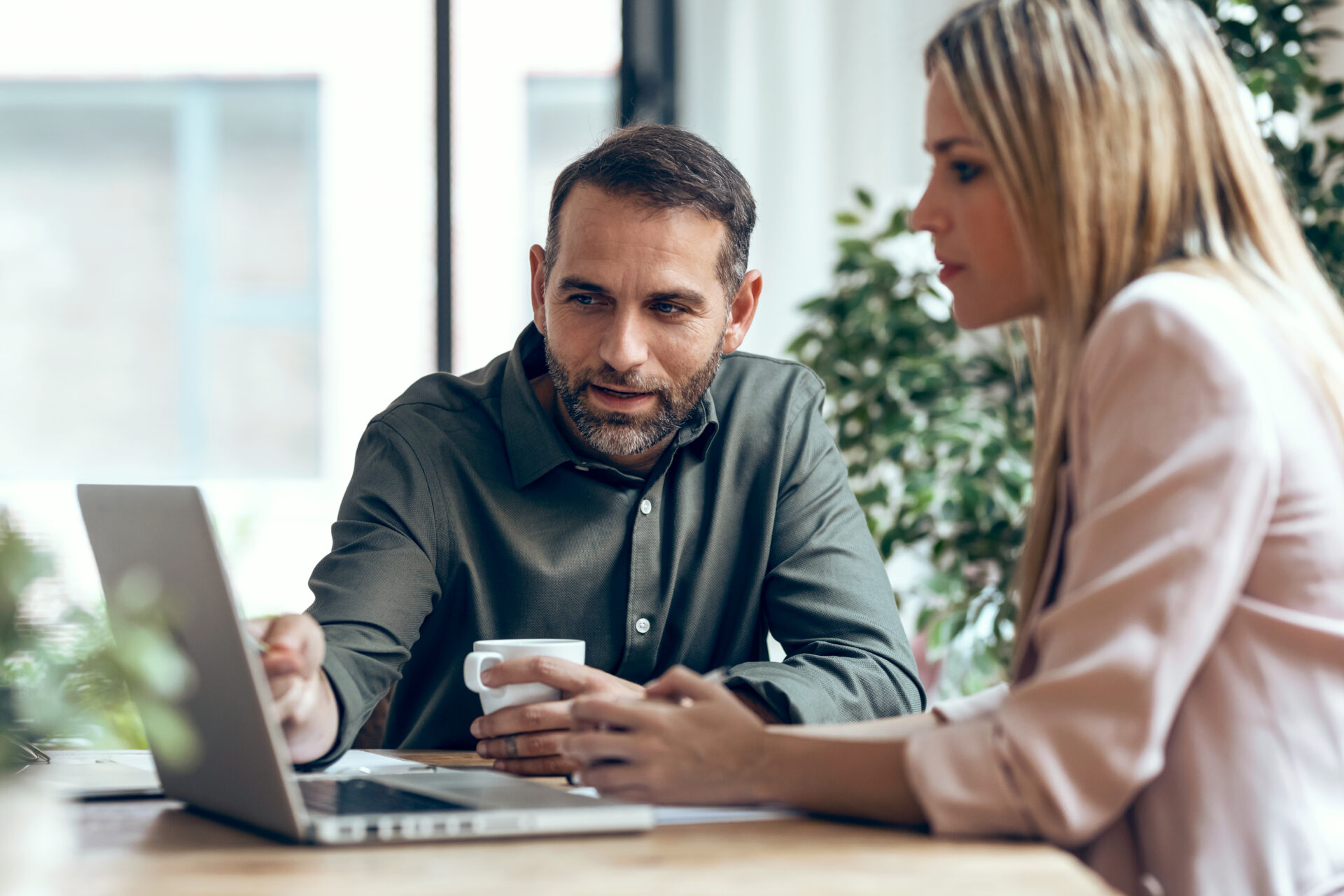 Man and woman looking a laptop together in a brightly lit office