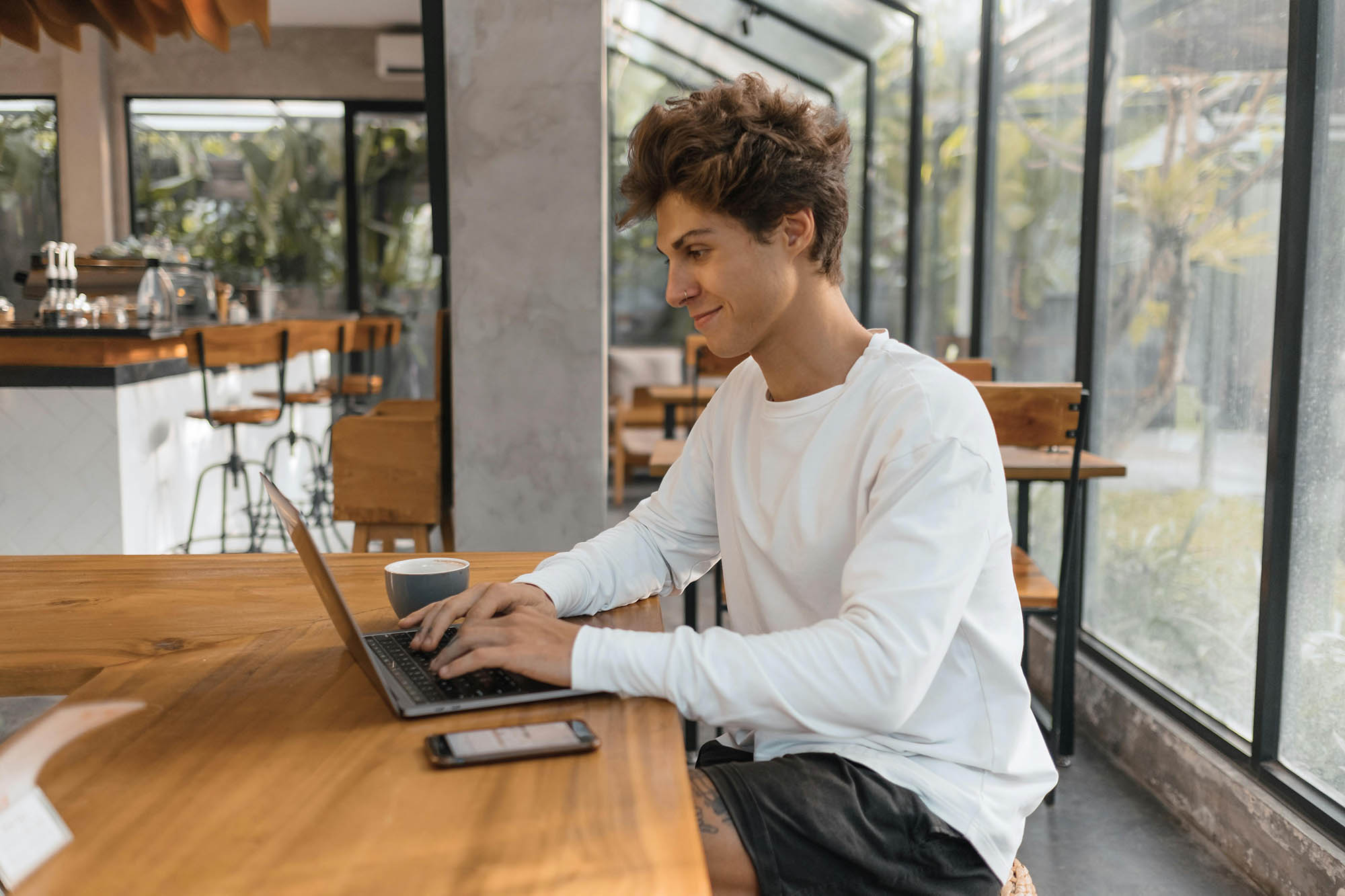 CIO working remotely on laptop with coffee while managing financial reporting tasks