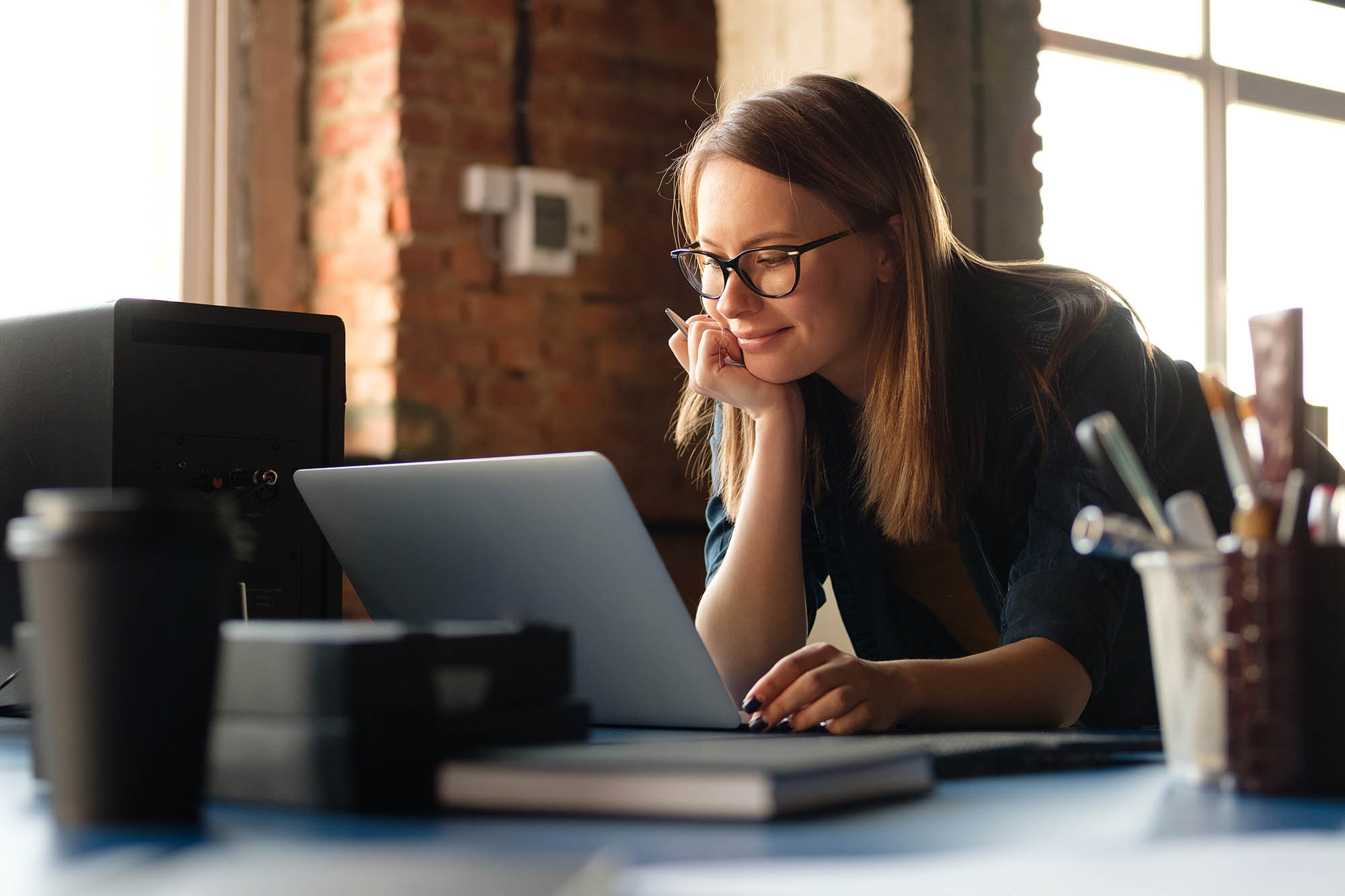 Finance professional working on laptop using transaction matching software in office